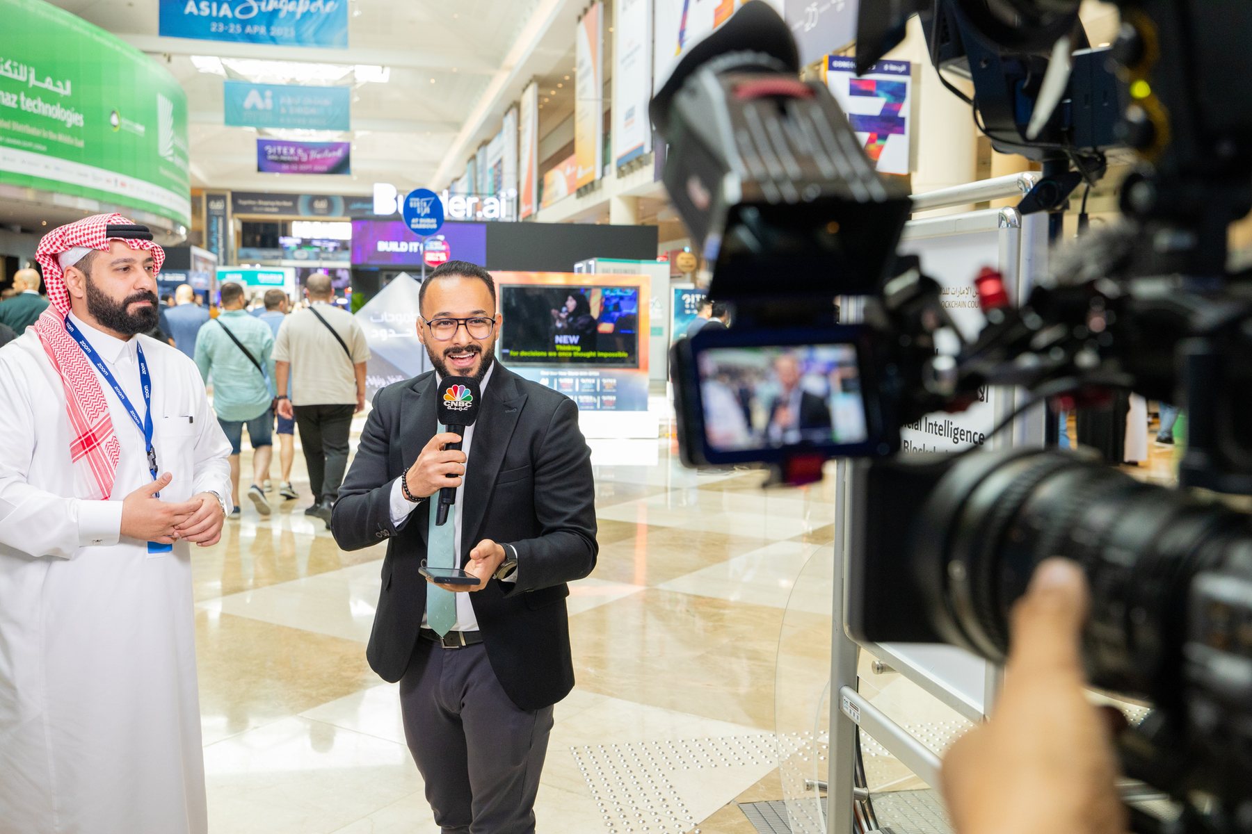 Isuru Marasinghe's production team filming CNBC floor coverage at a technology expo